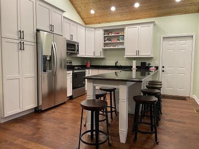 A kitchen with wood floors and a bar stools.