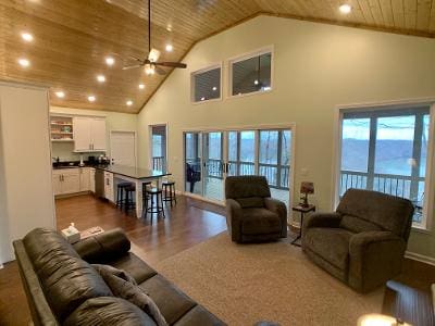 A living room with wood ceilings and a fireplace.