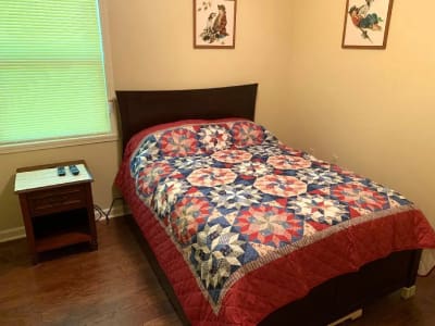 A bed in a room with a quilt on it.