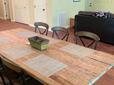 A wooden dining table with chairs in a living room.