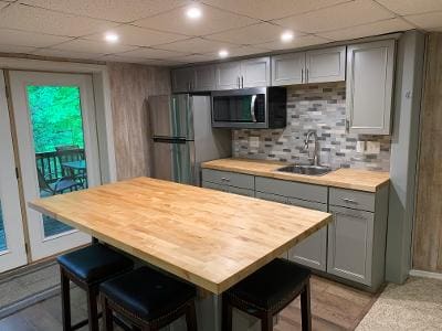 A kitchen with a wooden counter top and stools.