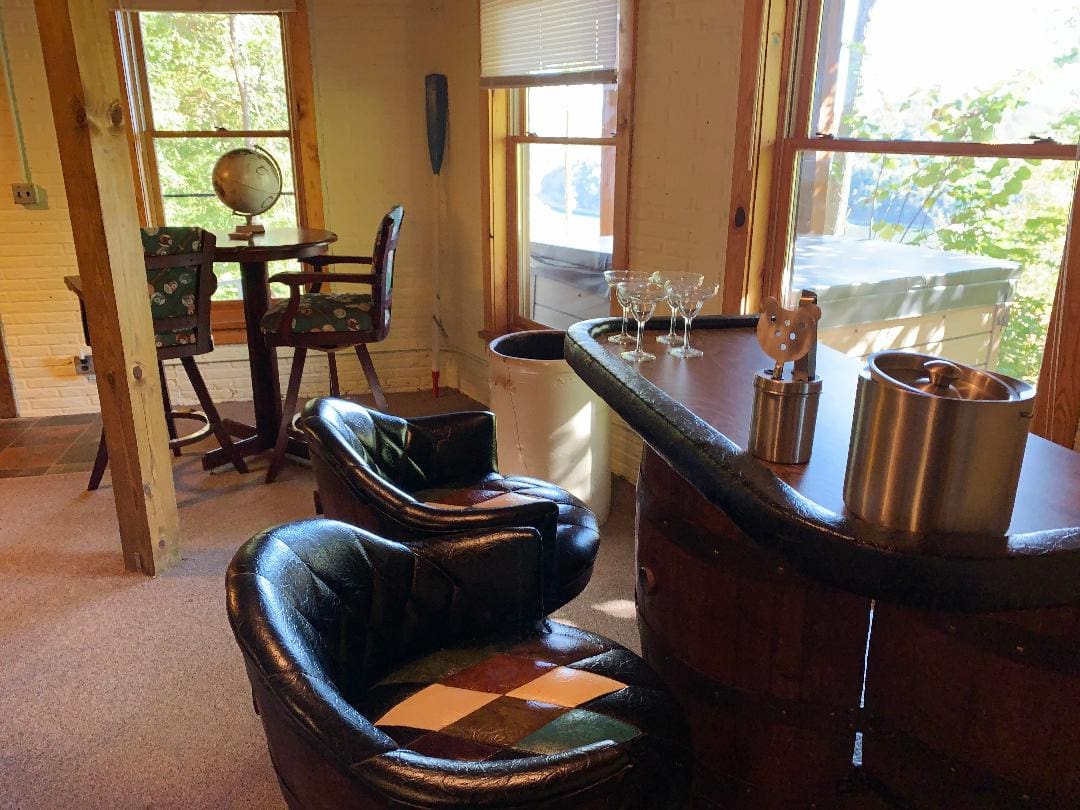 A living room with a bar and chairs.