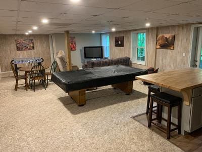 A room with a pool table and a tv.