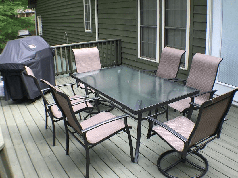 A dining table and chairs on a deck.