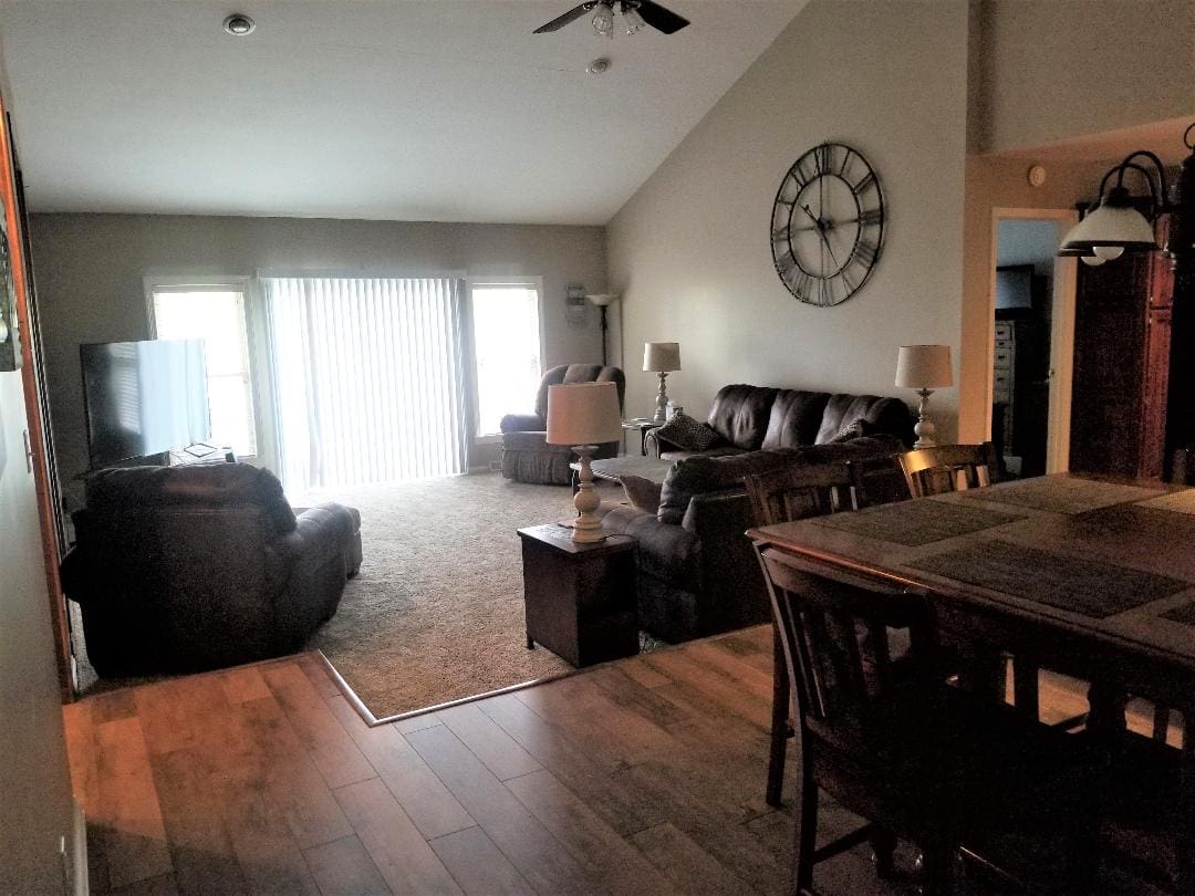 A living room with wood floors and a clock.