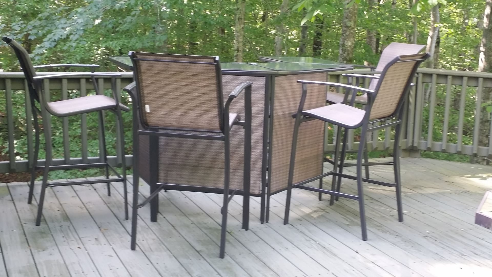 A patio table and chairs on a wooden deck.