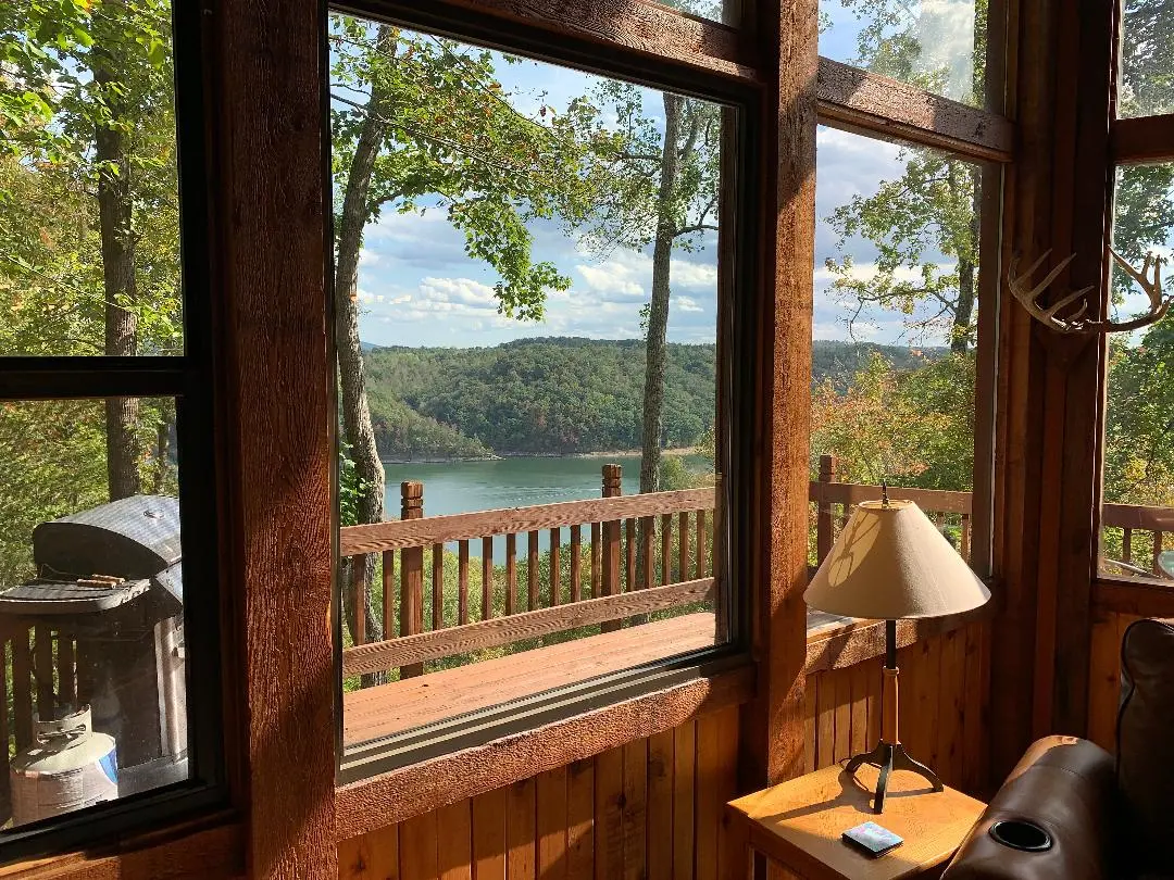 A living room with a fireplace and a view of a lake.