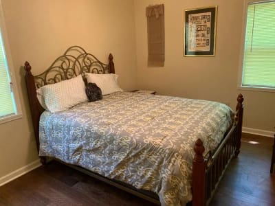 A bed in a bedroom with hardwood floors.