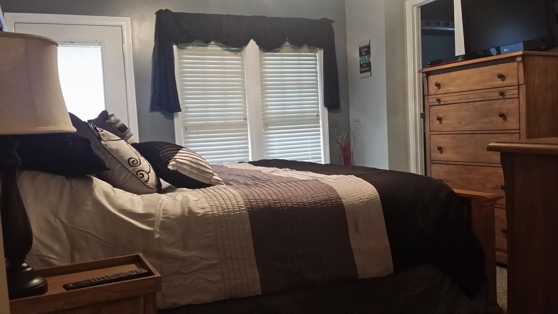 A bedroom with a bed and dresser in it.