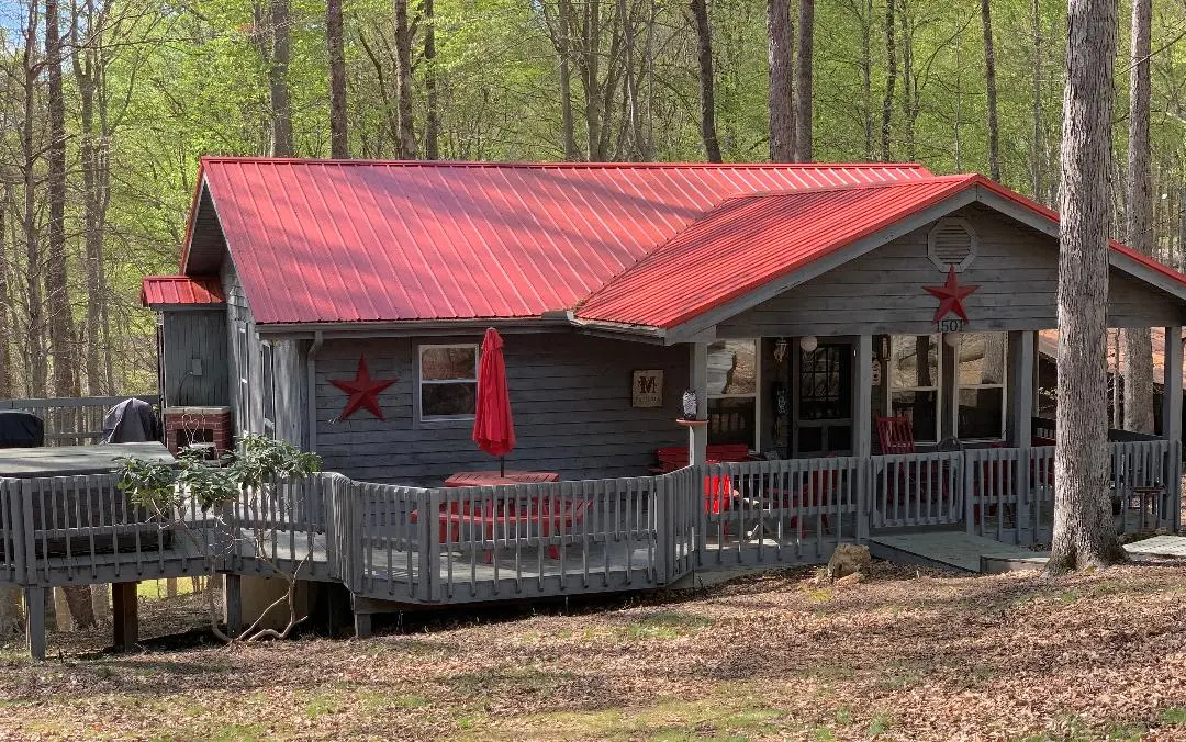 A cabin in the woods with a red roof.