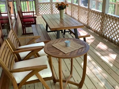 A screened in porch with a table and chairs.