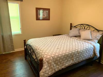 A bedroom with a bed and a bedside table.