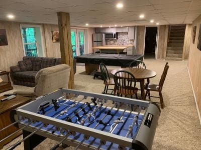 A room with a foosball table and couches.