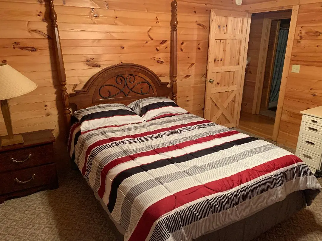 A bedroom with a bed and a dresser.