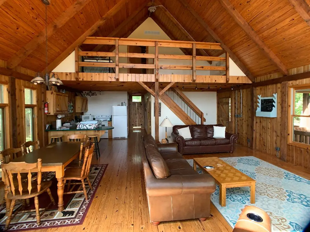 A living room and dining room in a log cabin.