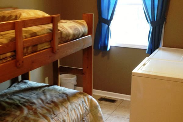 A small room with a bunk bed and a washing machine.