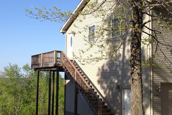 A house with stairs leading up to a tree.