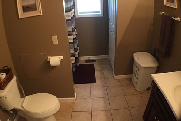 A bathroom with a toilet, sink and shower.