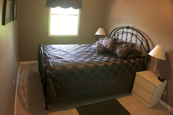 A bed in a room with a bedside table.