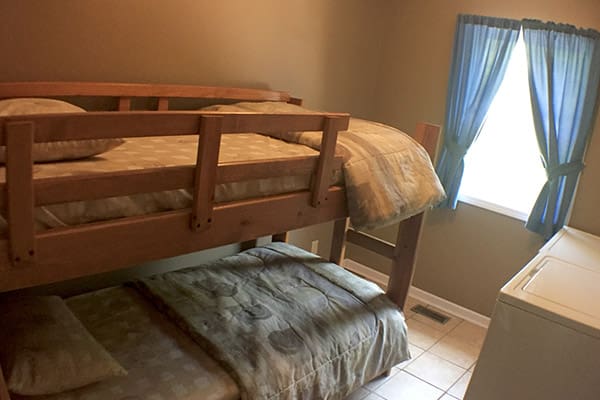 A bunk bed in a room with a washer and dryer.