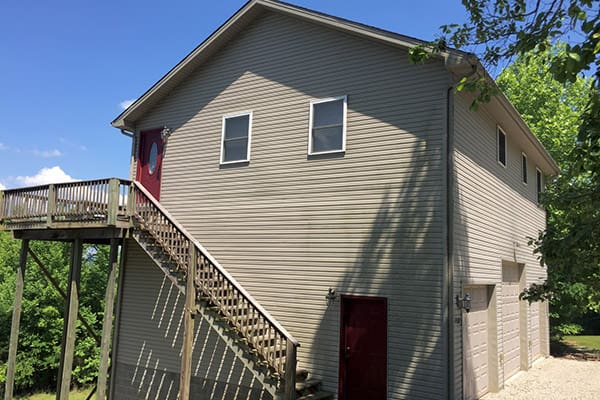 A house with stairs leading up to a deck.