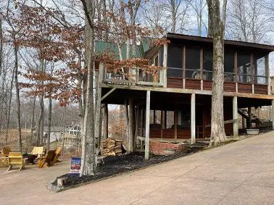 A house with a deck on the side of the road.