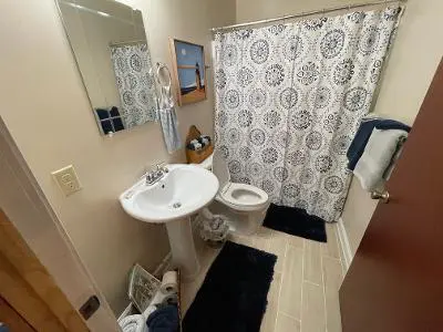 A bathroom with a toilet, sink and shower curtain.