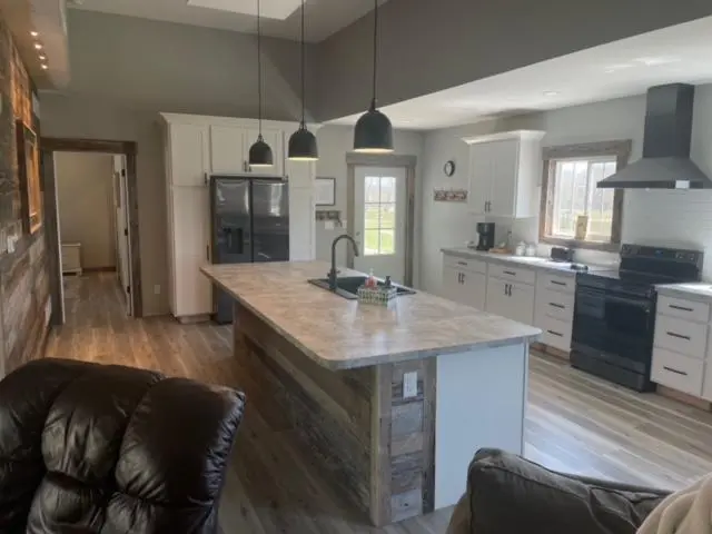 A kitchen with wood floors and a large island.