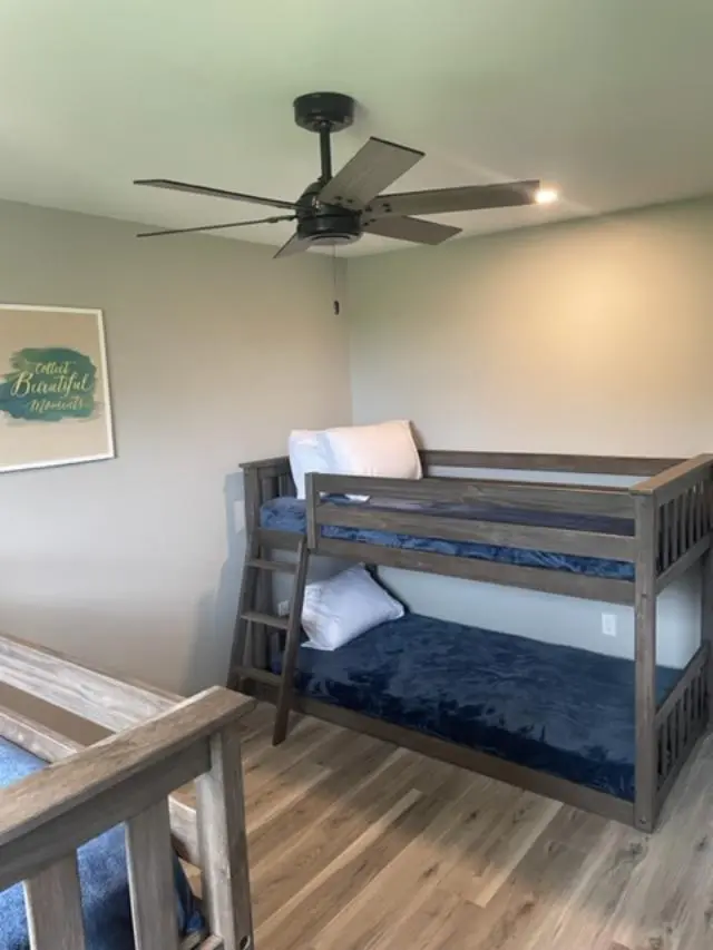 Two bunk beds in a room with a ceiling fan.