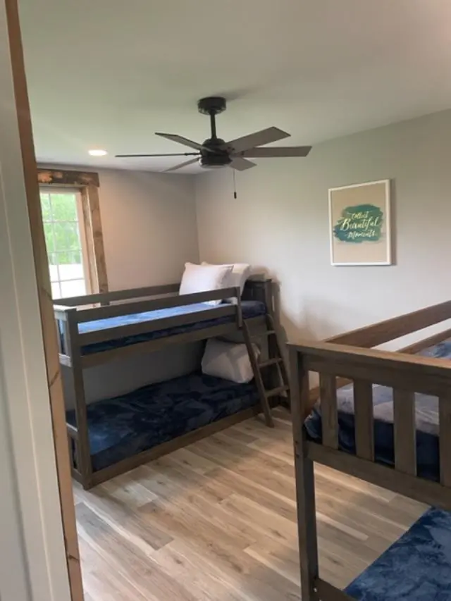 Two bunk beds in a room with a ceiling fan.