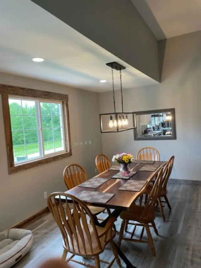 A dining room with a wooden table and chairs.