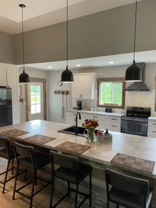 A kitchen with a large island and bar stools.