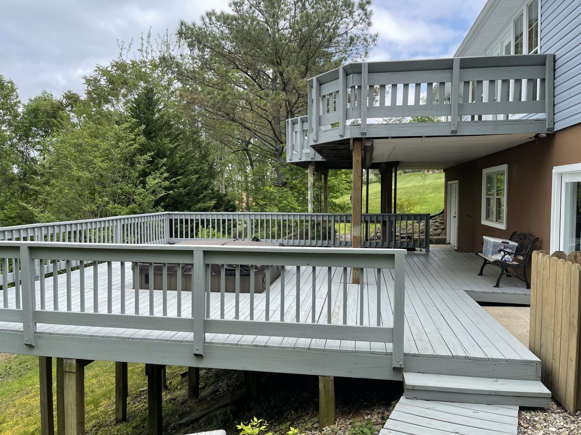 A deck with a wooden railing and a fire pit.