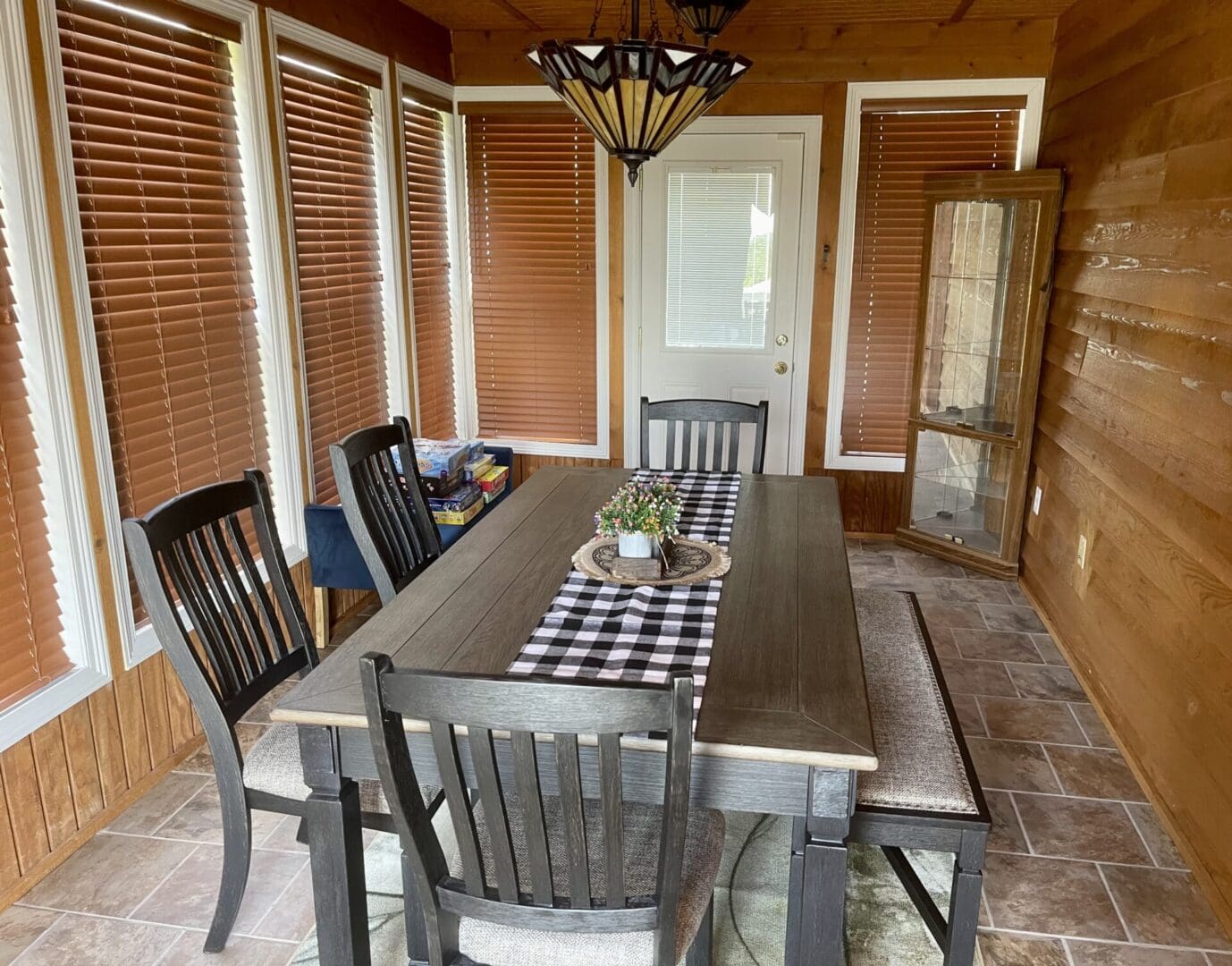 A dining room in a log cabin with a table and chairs.