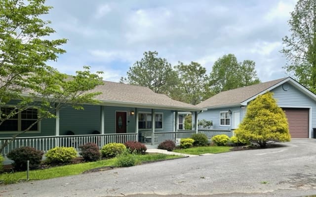 A blue home with a driveway and a garage.