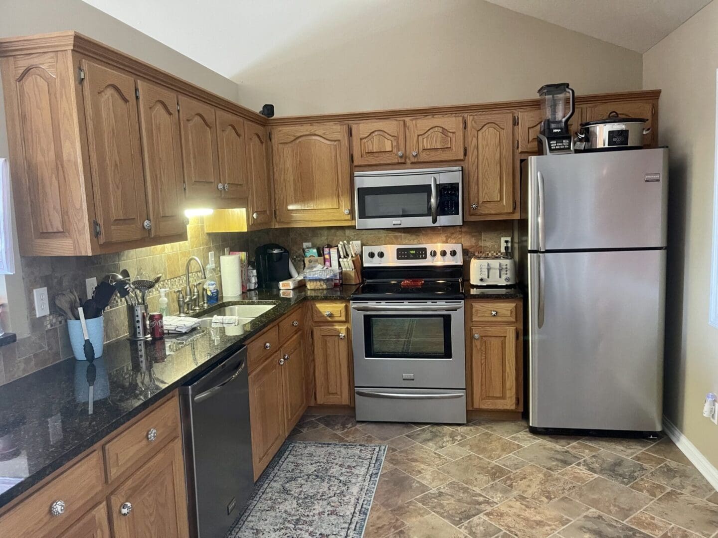 A kitchen with stainless steel appliances and wood cabinets.