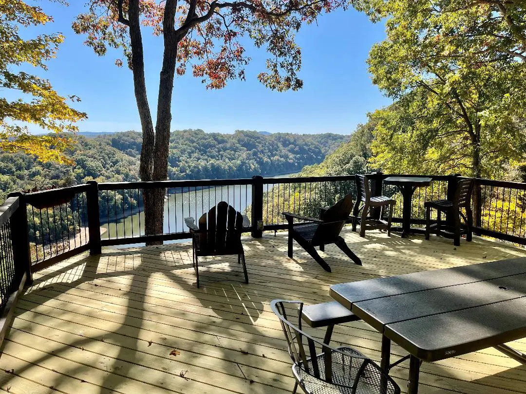 A deck overlooking a river and trees.