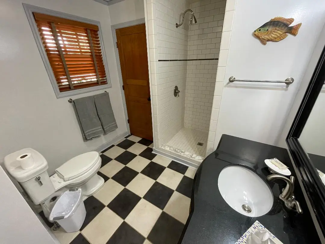 A bathroom with a black and white checkered floor.