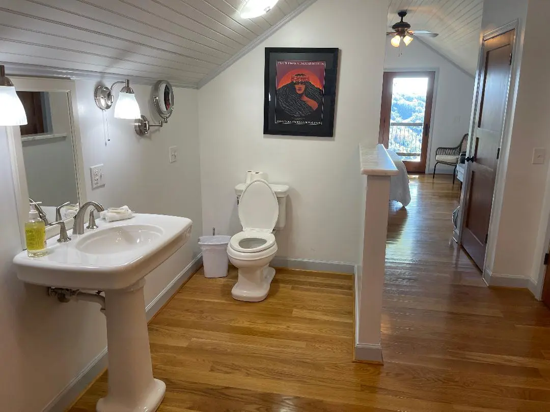 An attic bathroom with a toilet and sink.