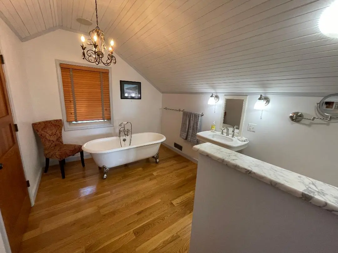 A bathroom with a bathtub and a chandelier.