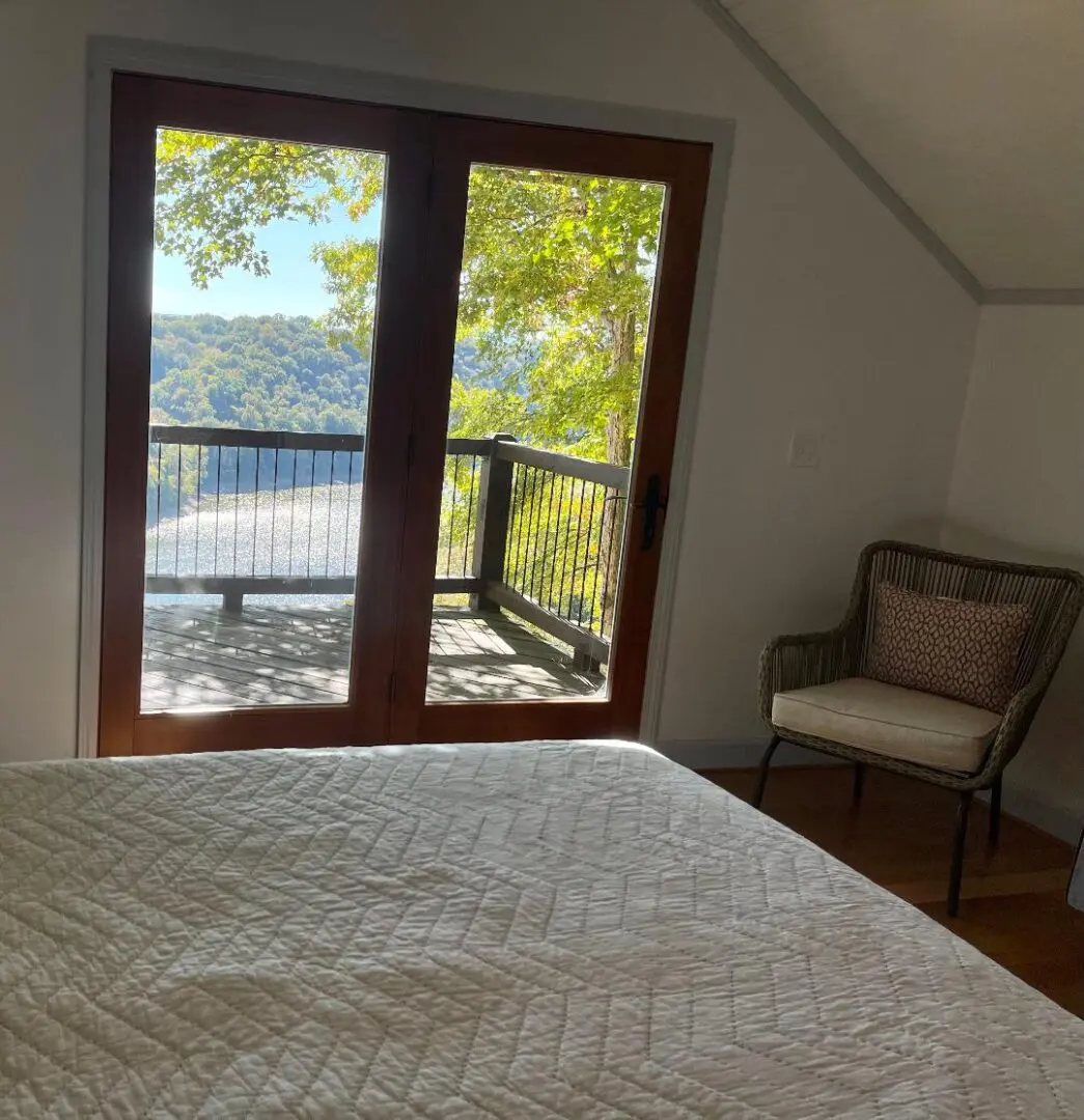 A bed in a bedroom with a view of a lake.