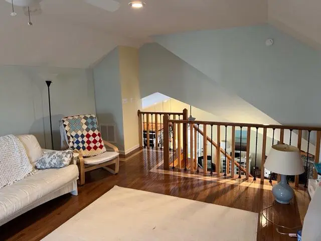 A living room with hardwood floors and a staircase.