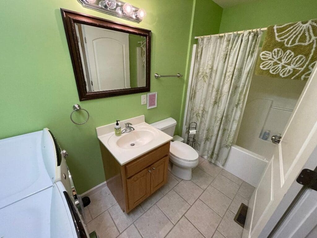 A bathroom with green walls and a sink.