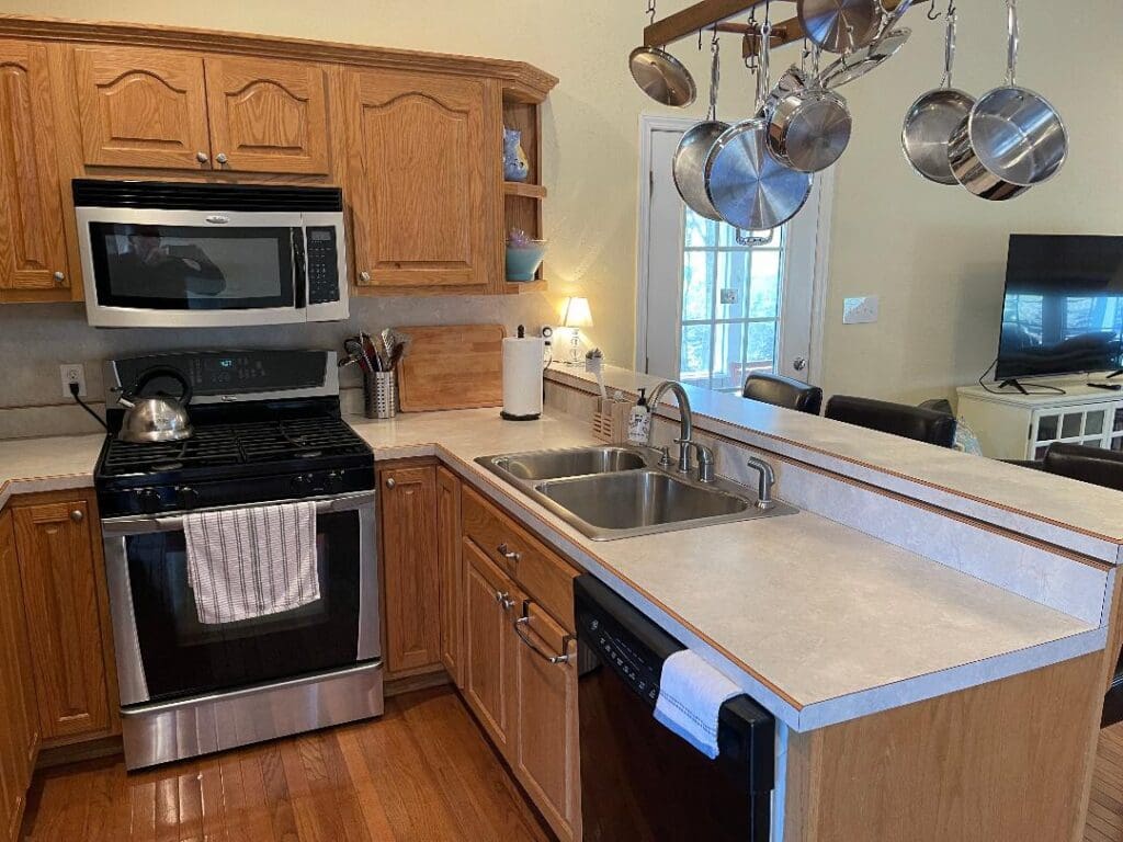 A kitchen with stainless steel appliances and wooden cabinets.