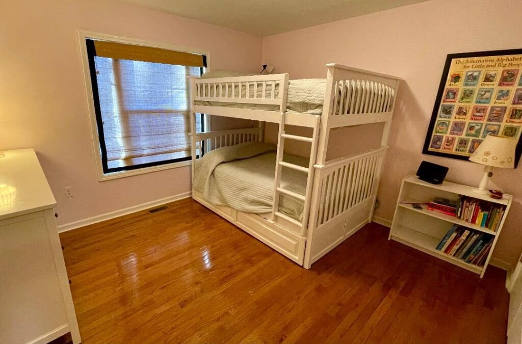 A bedroom with a bunk bed and a dresser.