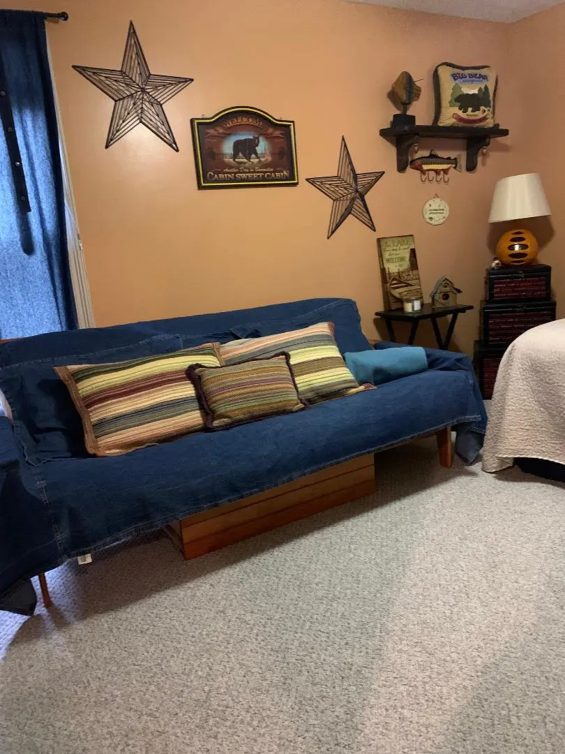 A bedroom with a blue couch and a bed.