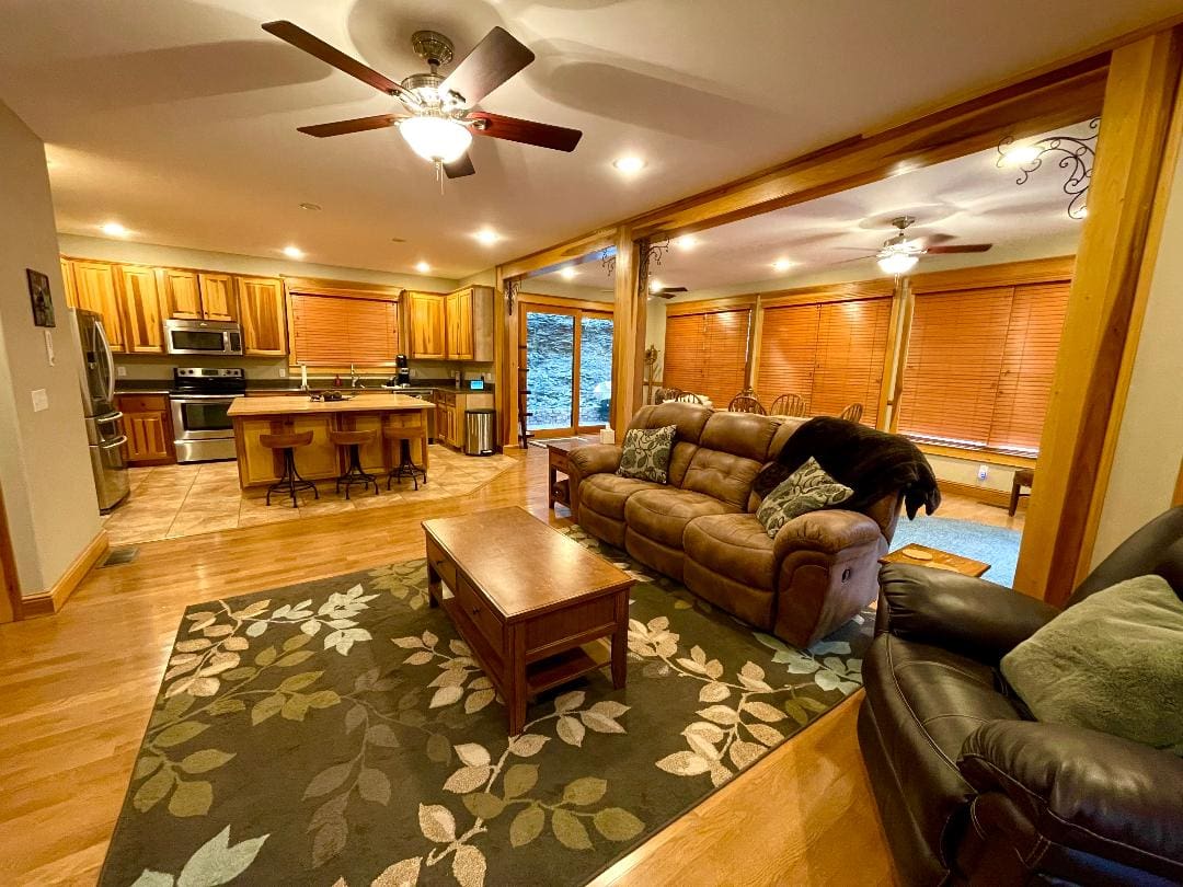 Cozy living room with adjacent open kitchen, featuring wooden cabinetry and a breakfast bar.