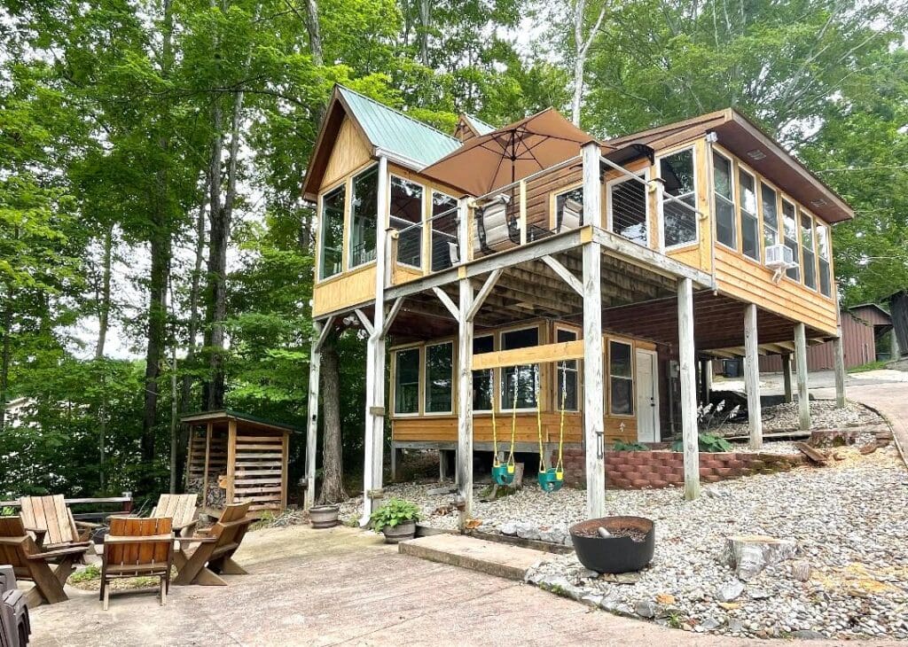Two-story cabin with outdoor seating area.