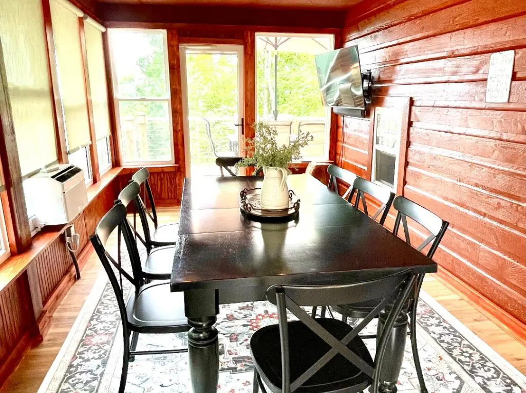 Rustic dining room with black table and chairs.