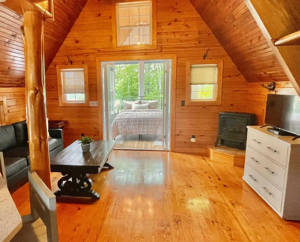 Cozy wooden cabin interior with bedroom view.